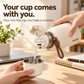 Milk White FULOO bottle pouring through the open inner lid into its metal-lined cup cap at a desk.