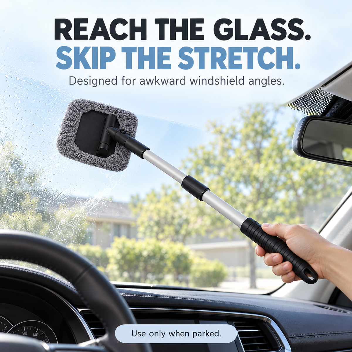 Microfiber windshield cleaner reaching across the inside of a parked car's windshield.